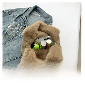 Macro detail of khaki faux fur bucket bag showing interior capacity with phone and lipstick