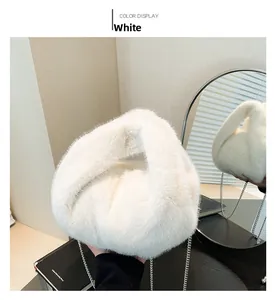 Close-up of white plush crossbody bucket bag with silver metal chain on dressing table