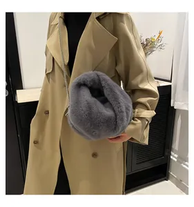 Detail of soft gray plush bucket bag with silver metal chain on a khaki trench coat
