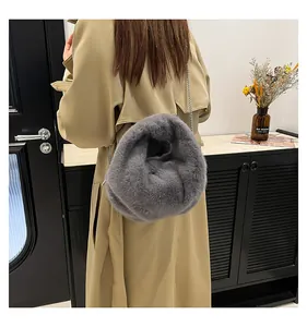 Detailed view of gray faux fur bucket bag with silver chain strap on a camel coat