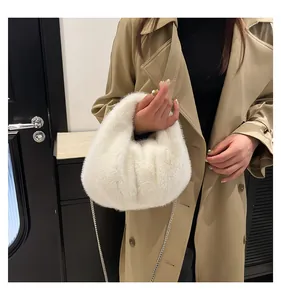 Detail of white plush bucket bag with silver chain strap on long autumn trench coat