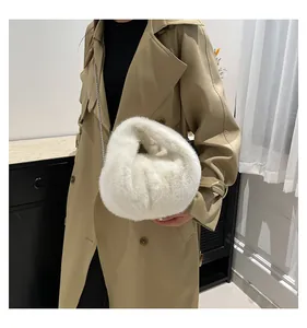 Detail of white faux fur handbag with soft plush texture and silver metal chain strap