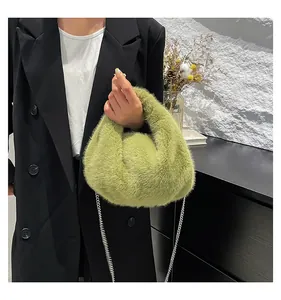 Close-up of green faux fur bucket bag with a stylish silver chain strap on a model
