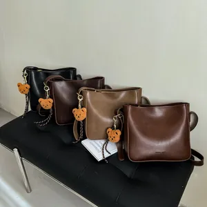 Sacs seau rétro en similicuir en quatre couleurs avec breloques d'ours et bandoulières