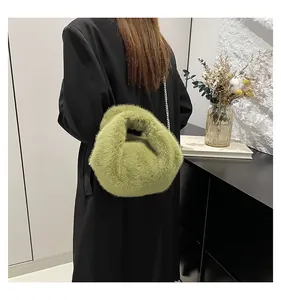 Detail of green faux fur bucket bag with thin metal chain strap for winter style