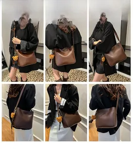 Vue détaillée du sac seau en cuir marron mat avec breloque d'ours orange en accessoire
