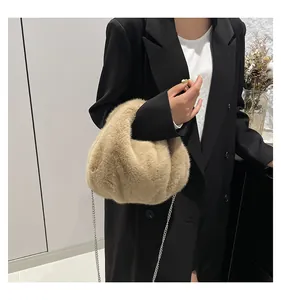 Detail view of the plush beige faux fur texture and silver chain strap on this shoulder bag