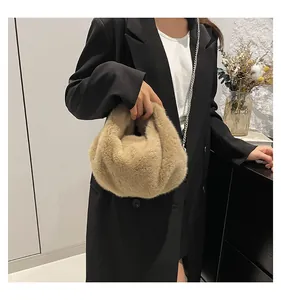 Detail of soft beige faux fur bucket bag with a slim silver chain strap for autumn