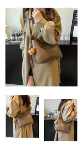 Gros plan d'un sac seau vintage marron avec un joli pendentif en forme d'ours en peluche