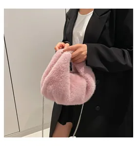Close-up of pink fluffy plush cloud bag with a silver chain strap on a model