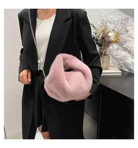 Detail showing plush pink faux fur texture and silver metal chain strap of the bucket bag