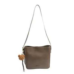 Sac seau vintage marron en cuir avec pendentif ours en peluche et bandoulière
