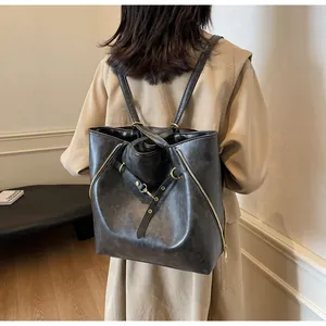 Dettaglio della borsa tote convertibile grigio scuro con trama in pelle e zip