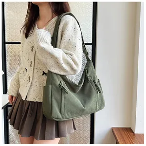 Detail einer grünen Cord-Hobo-Tasche mit geflochtenem Reißverschluss und Seitentasche