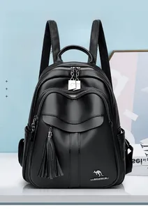 Detail of black pebbled leather backpack showing tassel zipper and silver hardware accents