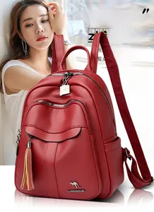 Detail of burgundy leather backpack featuring tassel zippers and kangaroo logo branding
