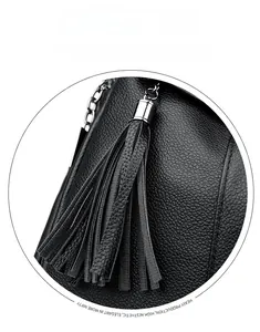 Macro detail of black lychee leather backpack with metallic tassel and silver hardware
