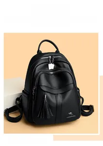 Detail of black pebbled leather backpack showing fringe pocket and silver dual zippers