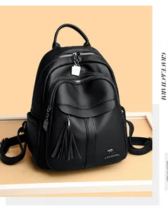 Close-up of black lychee texture leather backpack with tassel and silver metal zipper detail