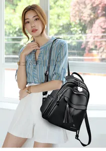 Close-up of black litchi grain leather backpack with fringe detail and kangaroo logo