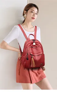 Macro shot of red pebble leather backpack detail with tassel and metal kangaroo logo