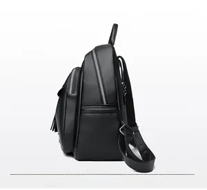 Side view of black faux leather backpack featuring pebble texture and fringe charm detail