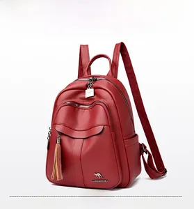 Detail view of red soft leather backpack featuring metal kangaroo logo and tassel