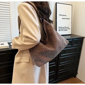 Detalle de un bolso tote marrón con pedrería plateada brillante y correa de cuero fino