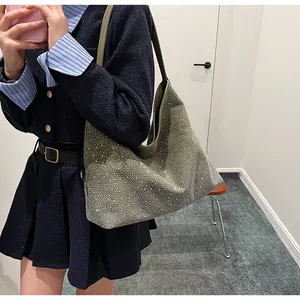 Primer plano de un bolso de hombro verde oscuro con pedrería llevado por una modelo