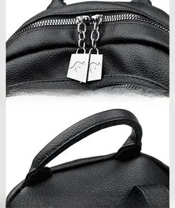 Macro shot of dual metal zippers with logo and reinforced handle on black leather bag