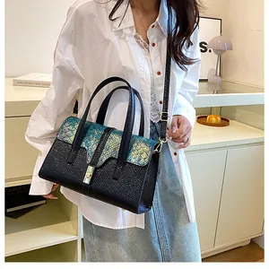 Detail of teal fish scale texture and gold buckle on a retro crossbody handbag