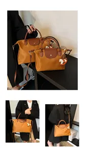 Macro detail of camel nylon tote bag with leather handles and rocking horse charm
