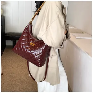 Detailed view of wine red quilted hobo bag with glossy finish and gold metal clasp
