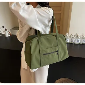 Detailed view of dark green large capacity nylon tote bag with front zipper pocket