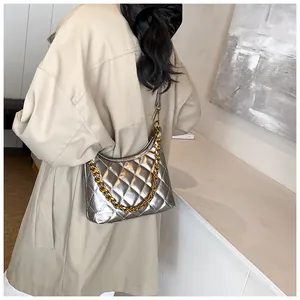 Detailed view of silver quilted saddle bag with metal chain strap and leather finish