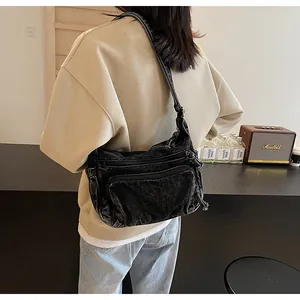 Detailed view of black multi-pocket canvas crossbody bag in vintage workwear style