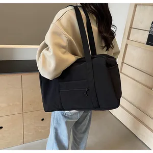 Large capacity black nylon tote bag shown on model for travel and yoga fitness