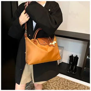 Close-up of contrast large tote bag with horse charm detail and leather handles