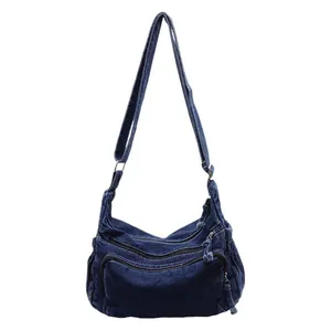 Deep blue denim travel tote with multi-layer zipper pockets and adjustable strap
