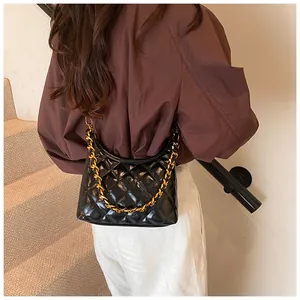 Detail of black quilted leather saddle bag featuring premium gold chain strap texture