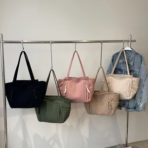 Borse tote in velluto a coste in cinque colori appese per un look minimalista