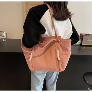 Dettaglio della borsa tote in velluto rosa con trama verticale e tasca laterale utile