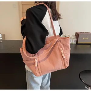 Dettaglio borsa tote in velluto a coste rosa con tasche laterali e decoro in corda