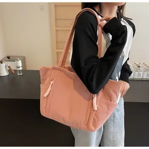 Dettaglio della borsa tote in velluto rosa con trama a coste e dettagli intrecciati