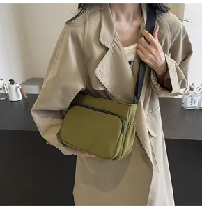 Détail du sac bandoulière en nylon vert olive avec sangle réglable et poches multiples