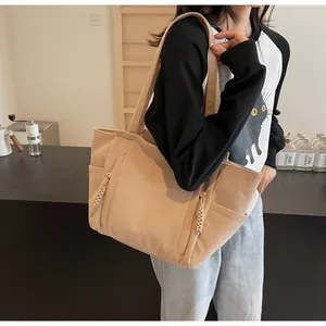 Dettaglio della borsa tote in velluto a coste beige con texture a coste e tasca laterale