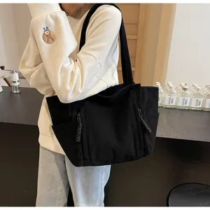 Dettaglio della borsa tote in velluto nero con texture spessa e tirazip in corda intrecciata