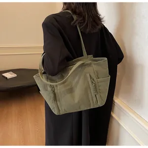 Dettaglio della borsa tote in velluto a coste verde salvia con trama e tasca laterale