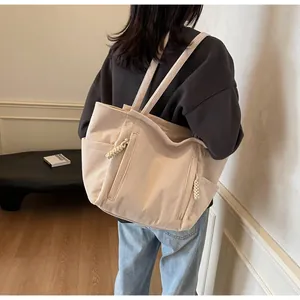 Dettaglio ravvicinato della trama in velluto a coste e delle tasche con zip della borsa shopper