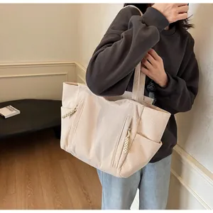 Dettaglio borsa tote in velluto a coste crema con zip in corda e tasca laterale
